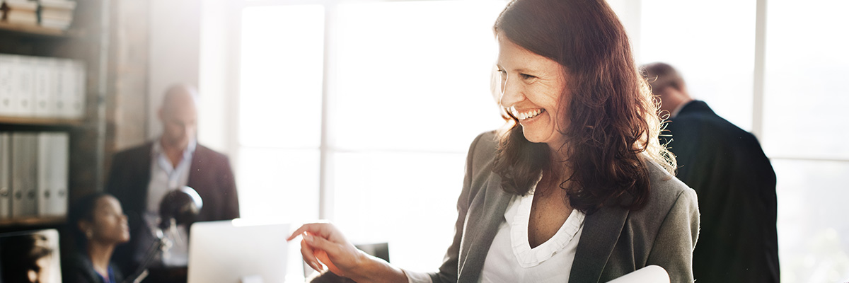 business woman smiling about enhanced productivity with JD Edwards Upgrade