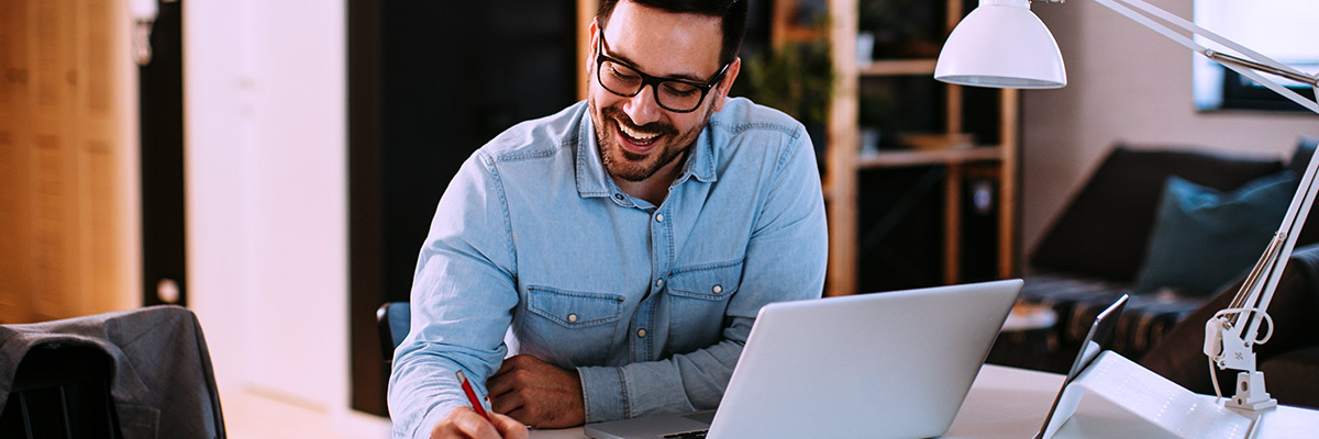 man working on laptop at home reviewing IT trends