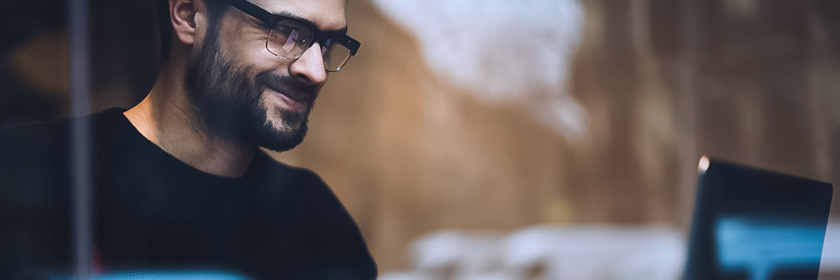 man looking at laptop researching internet of things