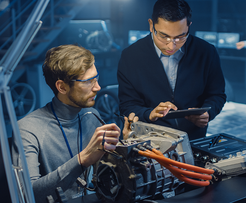 Two IT employees analyzing automotive part