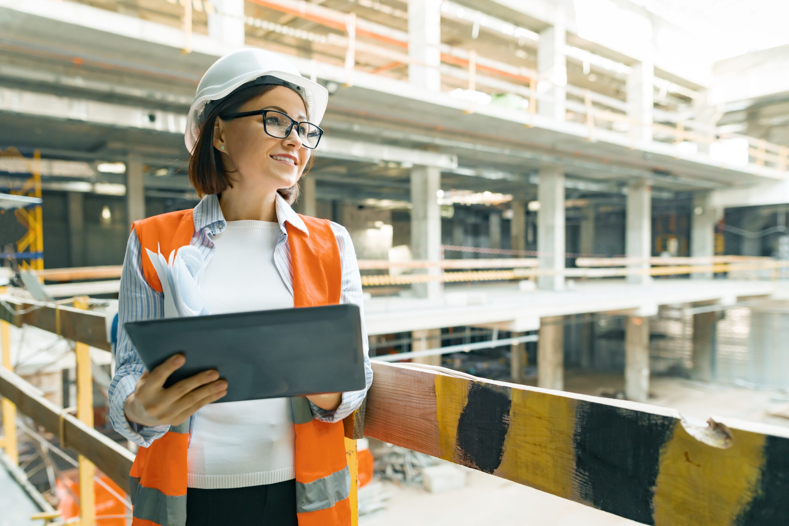Portrait of mature architect woman at a construction site. Building, development, teamwork and people concept